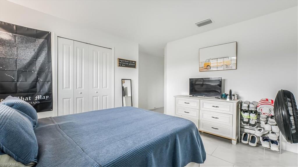 12252 Amber Waves Road Lehigh Acres, FL 33936 - Photo 28 of 35 a bedroom with a bed and a television