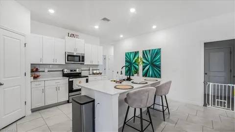 a kitchen with stainless steel appliances kitchen island granite countertop a stove a sink a microwave and a refrigerator