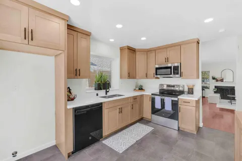 a kitchen with stainless steel appliances granite countertop a sink and stove top oven