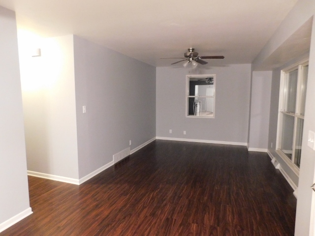 306 Errett Road Rochelle, IL 61068 - Photo 2 of 15 an empty room with wooden floor chandelier and windows