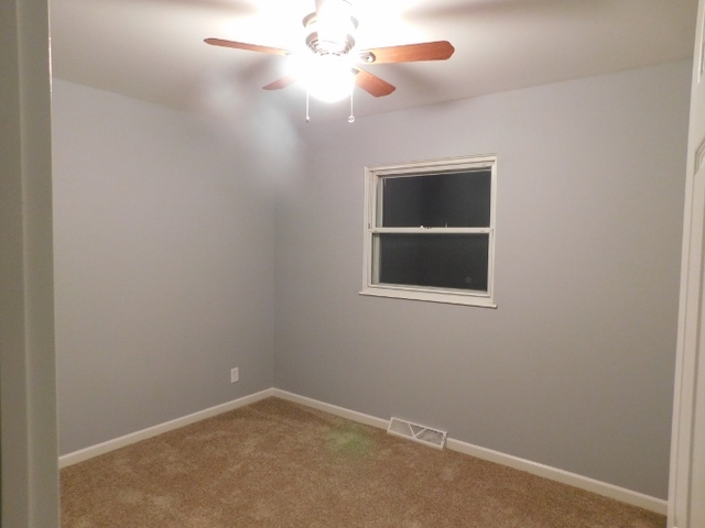 306 Errett Road Rochelle, IL 61068 - Photo 6 of 15 an empty room with a window and ceiling fan