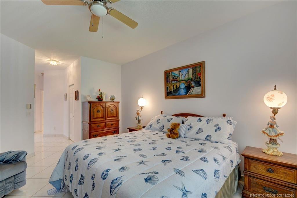 6789 Southeast Warwick Lane Stuart, FL 34997 - Photo 13 of 24 a bedroom with a bed and a dresser