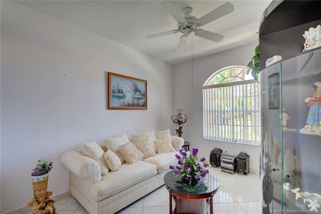 6789 Southeast Warwick Lane Stuart, FL 34997 - Photo 16 of 24 a living room with furniture flowers and a chandelier