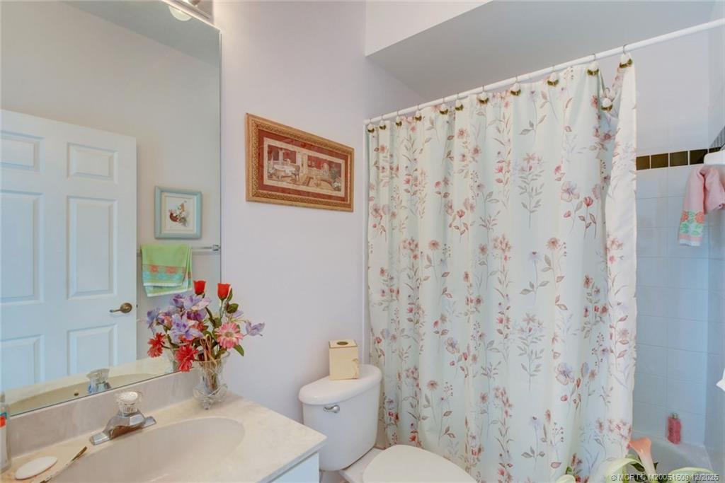 6789 Southeast Warwick Lane Stuart, FL 34997 - Photo 17 of 24 a bathroom with a sink toilet and mirror