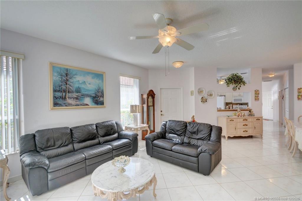 6789 Southeast Warwick Lane Stuart, FL 34997 - Photo 6 of 24 a living room with furniture and a chandelier