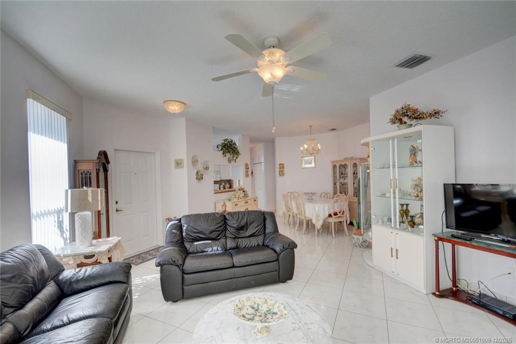 6789 Southeast Warwick Lane Stuart, FL 34997 - Photo 7 of 24 a living room with furniture a flat screen tv and kitchen view