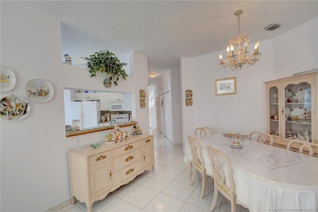 6789 Southeast Warwick Lane Stuart, FL 34997 - Photo 8 of 24 a dining room with furniture and chandelier