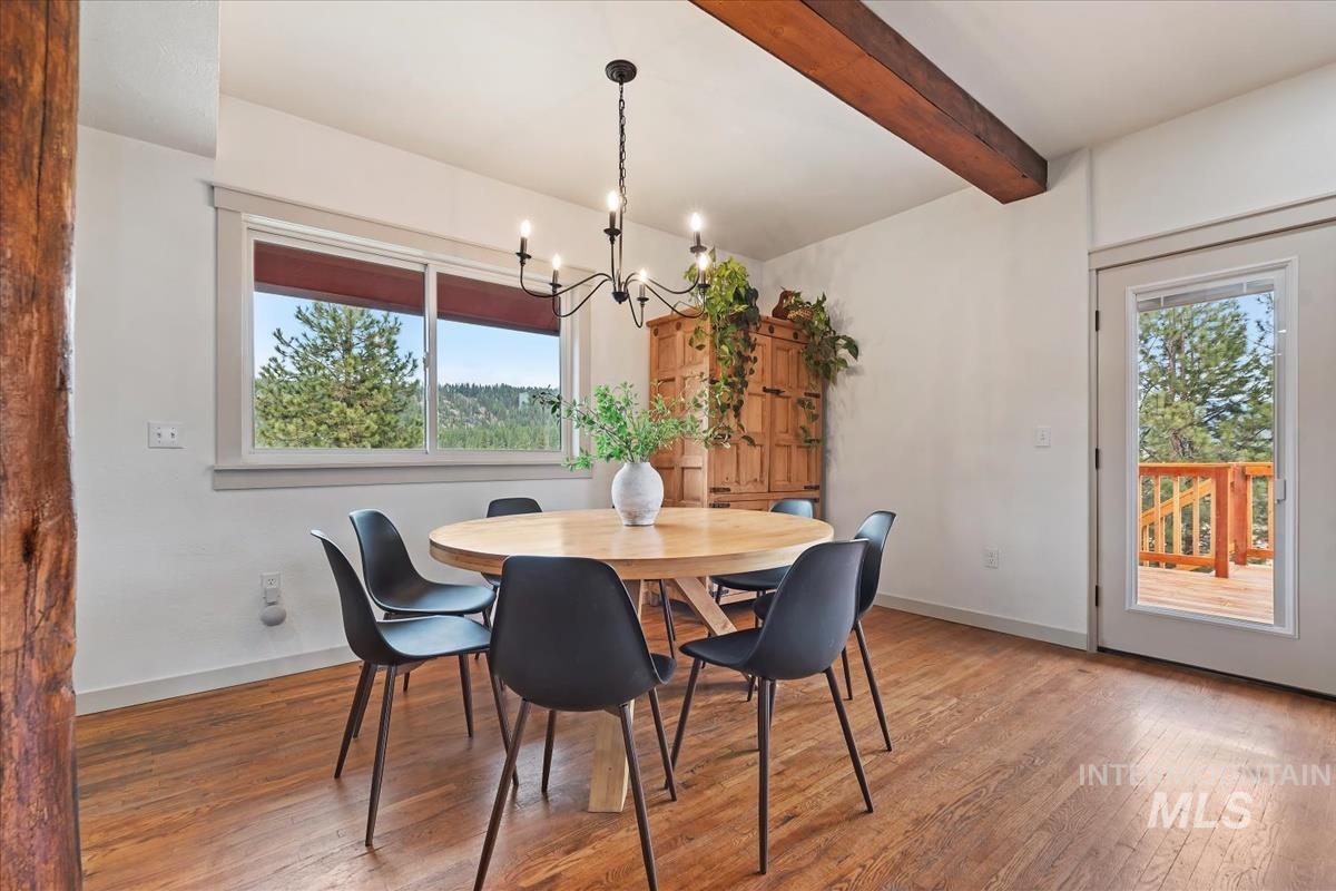 6 East Beck Road Garden Valley, ID 83622 - Photo 5 of 44 Dining area with wood-type flooring, beam ceiling, and hanging lights