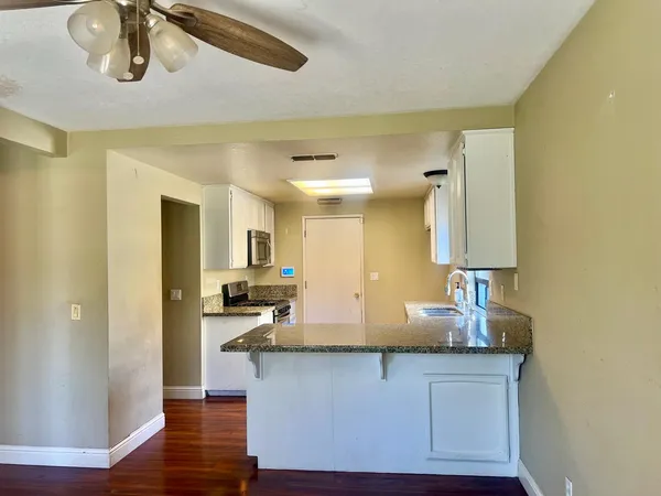 a bathroom with a granite countertop sink and a mirror
