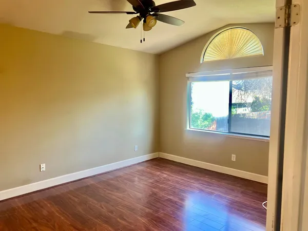 an empty room with a window and wooden floor