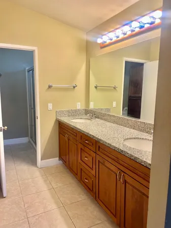 a spacious bathroom with a granite countertop sink and a mirror