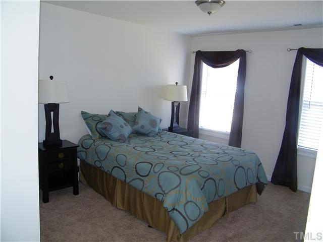 7116 Missionary Ridge Drive Raleigh, NC 27610 - Photo 10 of 12 a bedroom with a bed and a large mirror