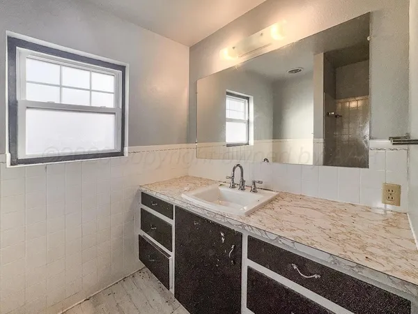 a bathroom with a granite countertop sink and a mirror