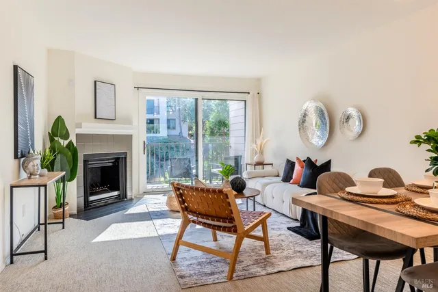 a living room with furniture a fireplace and a large window