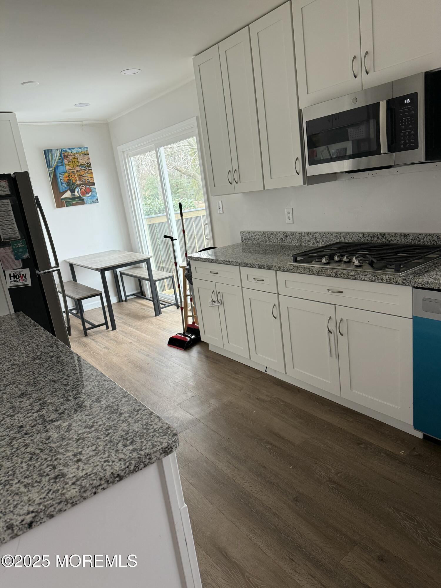 23 Hilltop Road West Long Branch, NJ 07764 - Photo 2 of 10 a kitchen with stainless steel appliances granite countertop a stove a microwave a sink and cabinets