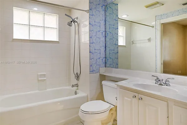 a bathroom with a granite countertop sink a toilet and a bathtub