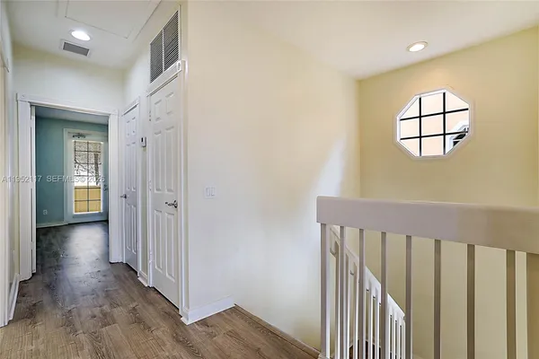 a view of a hallway with wooden floor and closet