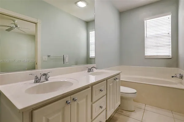 a bathroom with a granite countertop sink a toilet and bathtub