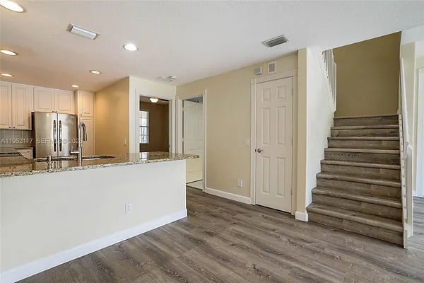a view of a kitchen with wooden floor and staircase