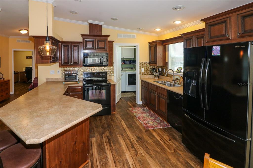 29200 South Jones Loop Road, Unit 715 Punta Gorda, FL 33950 - Photo 22 of 37 a kitchen with stainless steel appliances wooden floor dining table and chairs