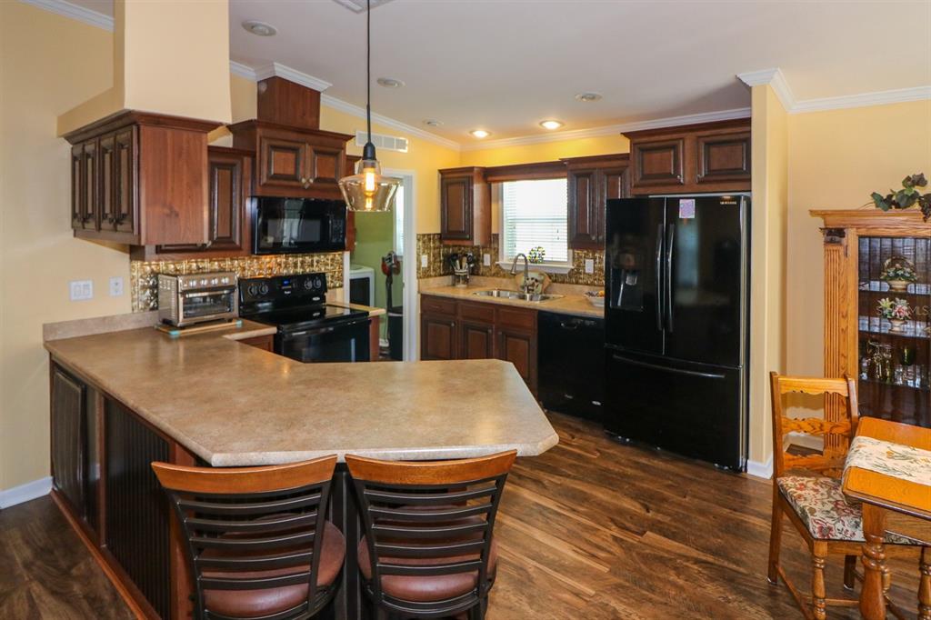 29200 South Jones Loop Road, Unit 715 Punta Gorda, FL 33950 - Photo 23 of 37 a kitchen with stainless steel appliances granite countertop a refrigerator a stove a sink dishwasher with a dining table and chairs