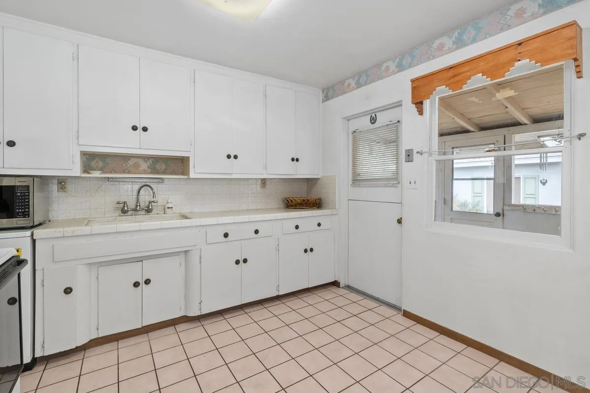 11179 Topo Lane Lakeside, CA 92040 - Photo 15 of 44 a kitchen with granite countertop white cabinets and white appliances