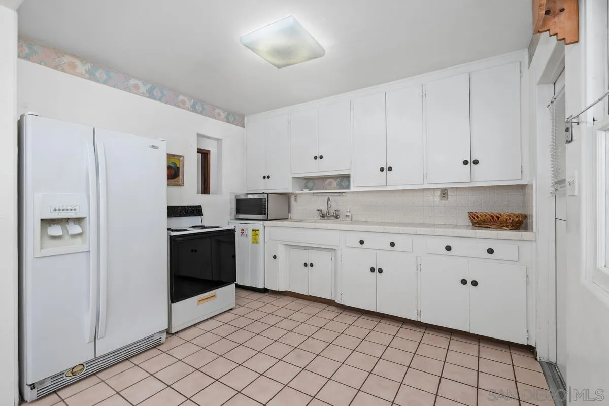 11179 Topo Lane Lakeside, CA 92040 - Photo 16 of 44 a kitchen with white cabinets and white appliances