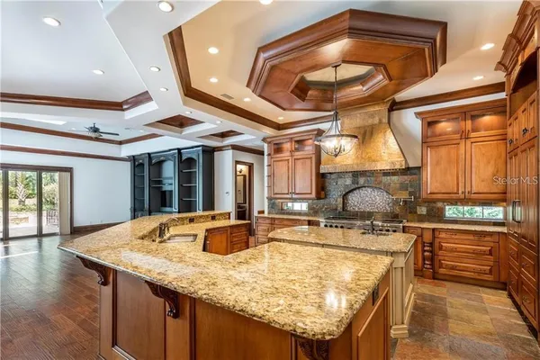 a kitchen with stainless steel appliances granite countertop a sink and a refrigerator