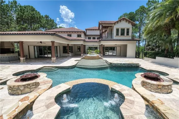 a view of a house with swimming pool and sitting area