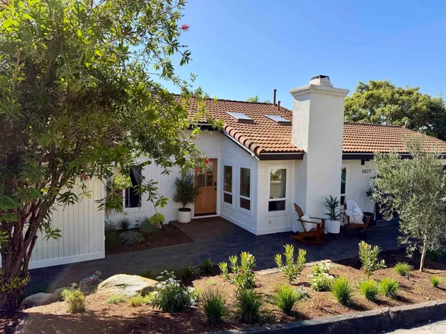 a front view of a house with a yard and a garden
