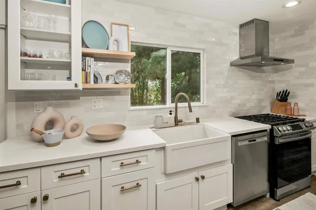 a large kitchen with kitchen island a large counter space a sink appliances and cabinets