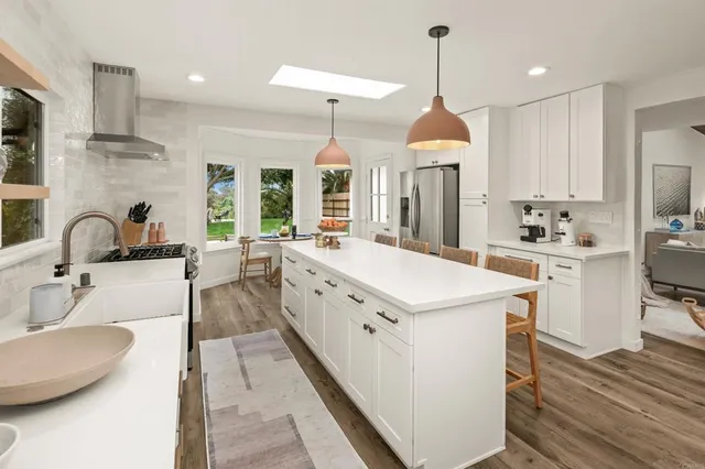 a dining room with wooden floor a glass table and chairs