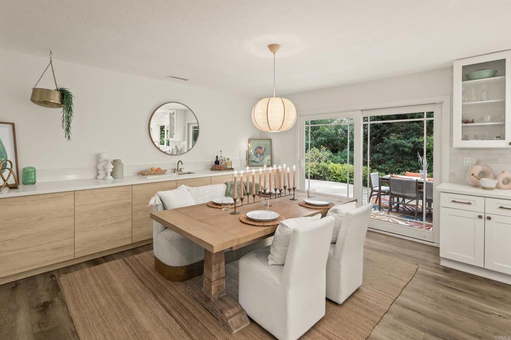 1427 Avocado Road Oceanside, CA 92054 - Photo 22 of 60 a dining room with wooden floor a glass table and chairs