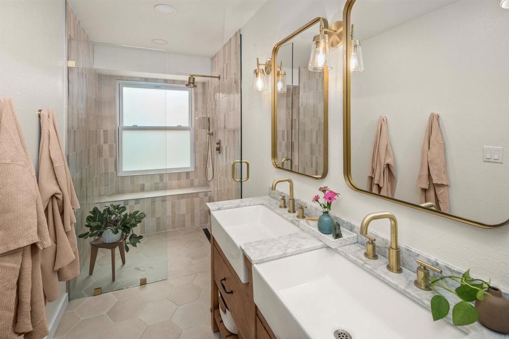 1427 Avocado Road Oceanside, CA 92054 - Photo 30 of 60 a bathroom with double vanity sinks a mirror and a shower