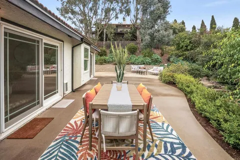 a view of a patio with couches and a table and chairs with garden view