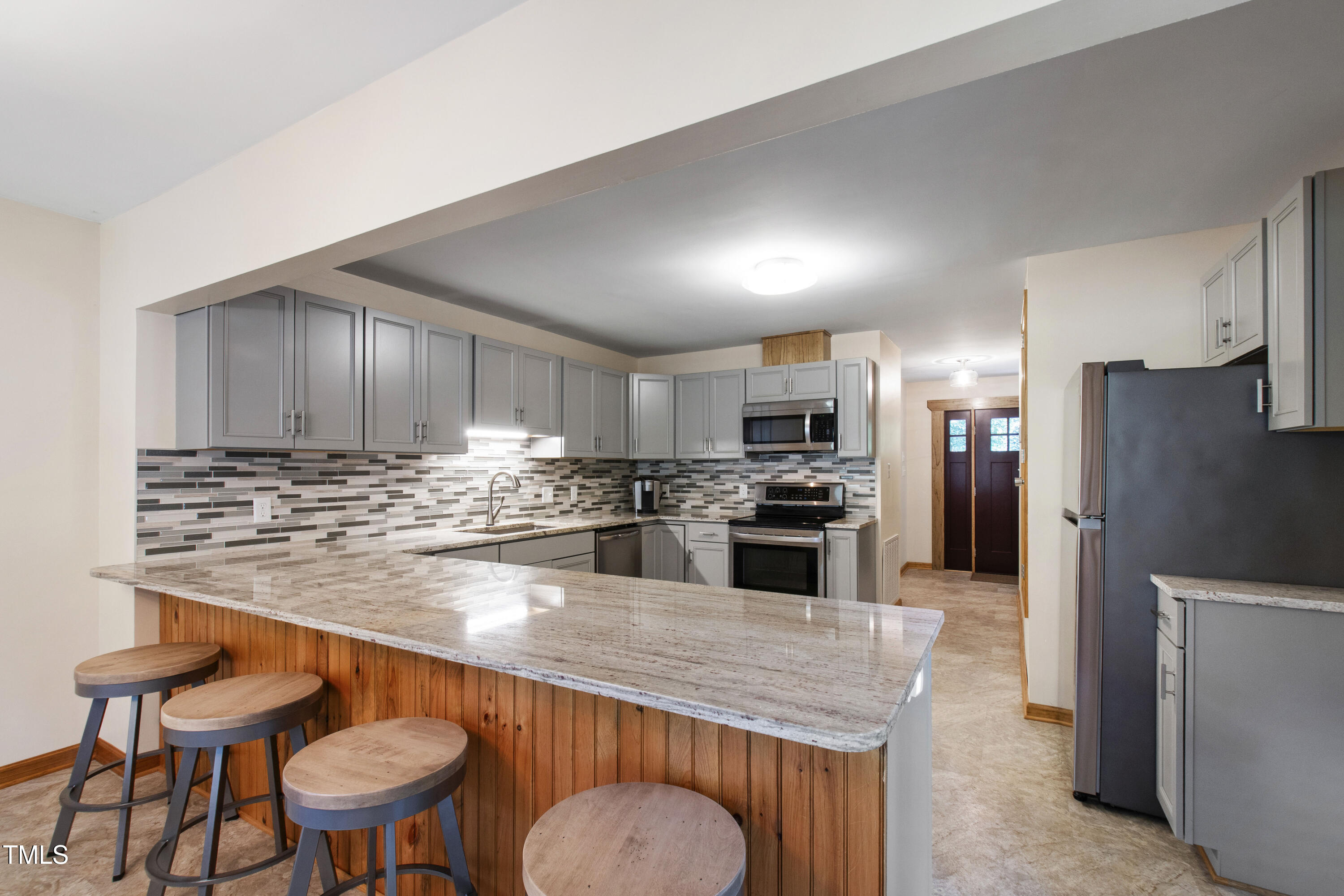 5415 Bradshaw Quarry Road Efland, NC 27243 - Photo 15 of 65 a kitchen with stainless steel appliances granite countertop a table chairs sink refrigerator and microwave