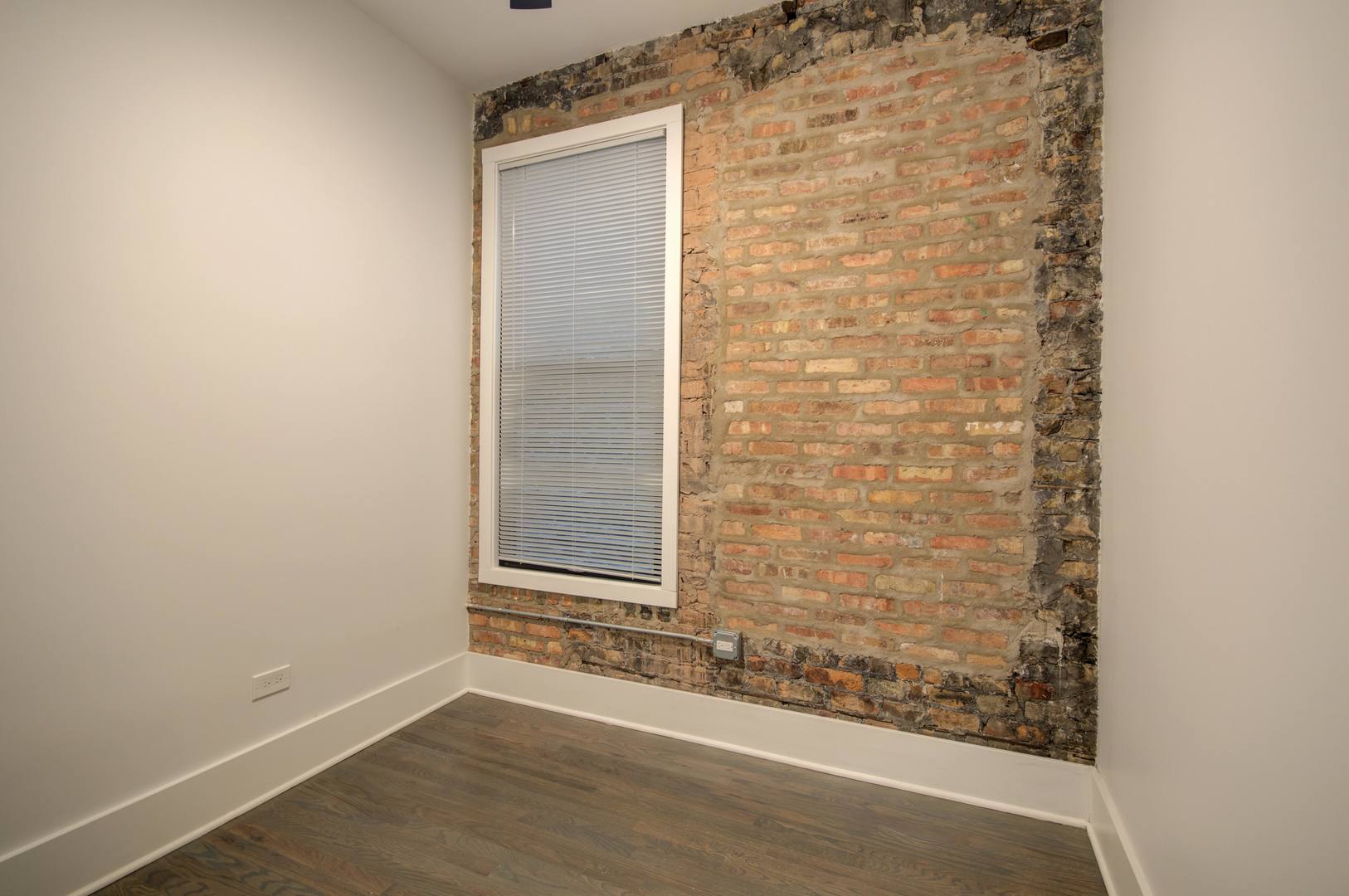 1917 South Racine Avenue, Unit 2F Chicago, IL 60608 - Photo 5 of 13 an empty room with wooden floor and windows
