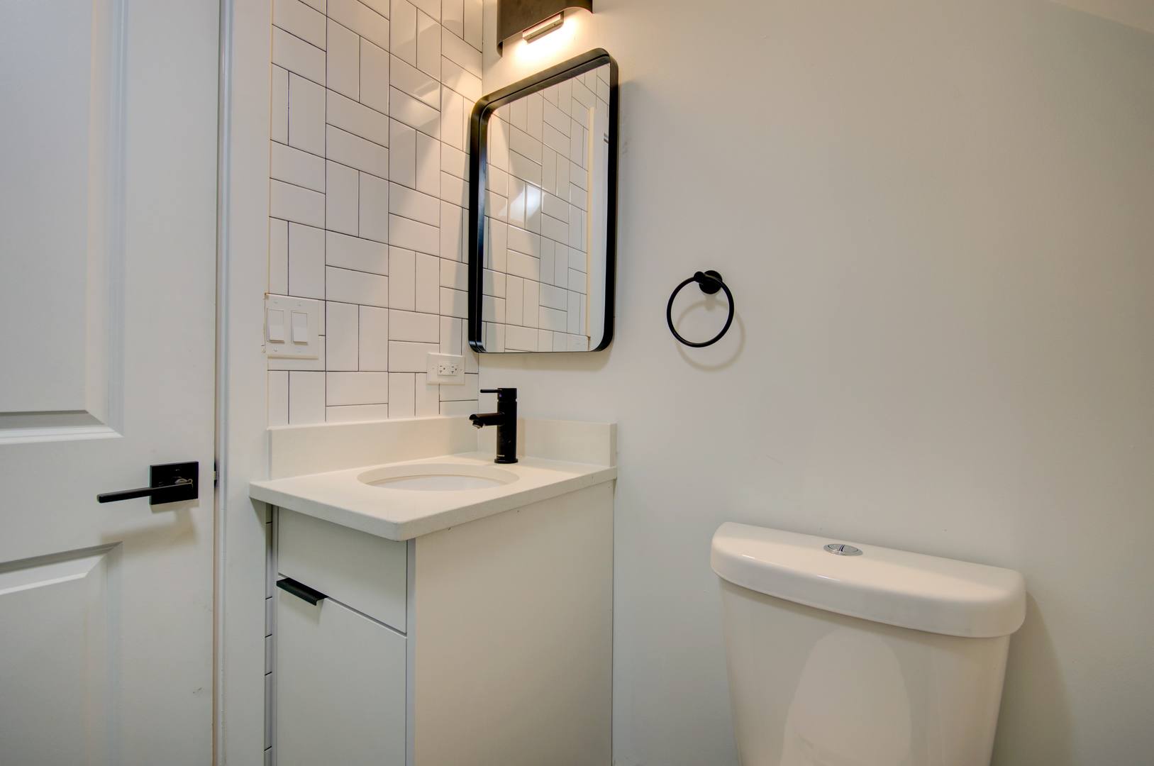 1917 South Racine Avenue, Unit 2F Chicago, IL 60608 - Photo 9 of 13 a bathroom with a granite countertop toilet sink and mirror