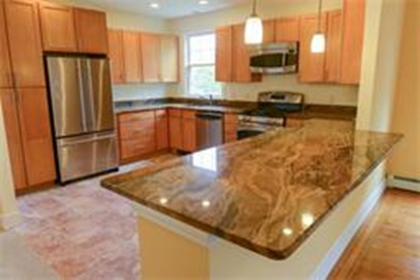 71 Fordham Road, Unit 71 Newton, MA 02465 - Photo 3 of 15 a kitchen with stainless steel appliances granite countertop a refrigerator a stove and a sink with wooden floor