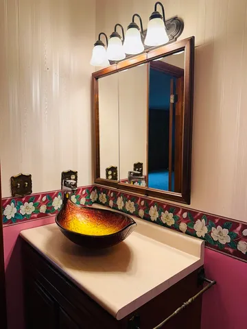 a bathroom with a granite countertop sink and a mirror