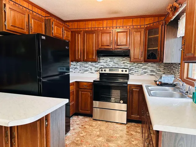 a kitchen with stainless steel appliances a stove refrigerator sink and microwave