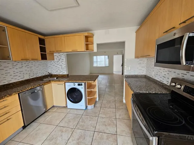 a kitchen with granite countertop a stove and a sink