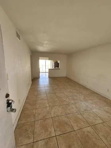 a view of a livingroom with an empty space and a window