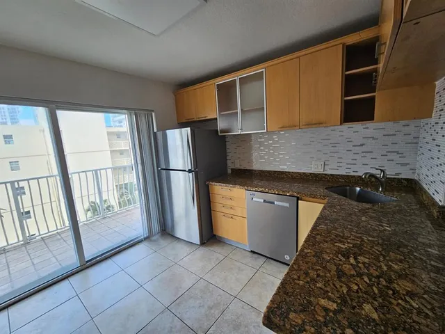 a kitchen with a refrigerator and a stove top oven