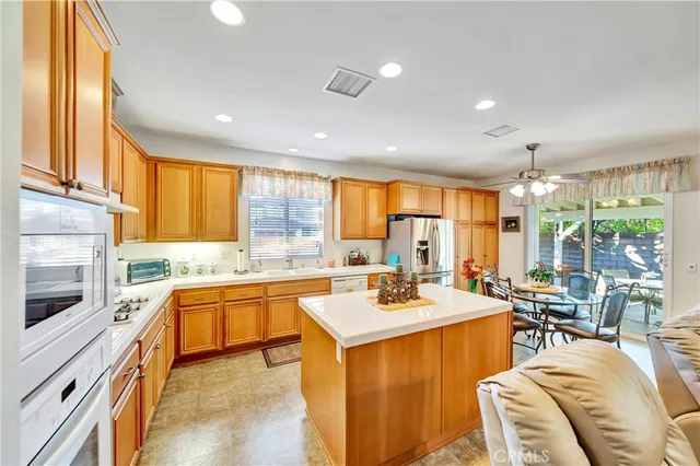 a large living room with stainless steel appliances kitchen island granite countertop a sink and cabinets