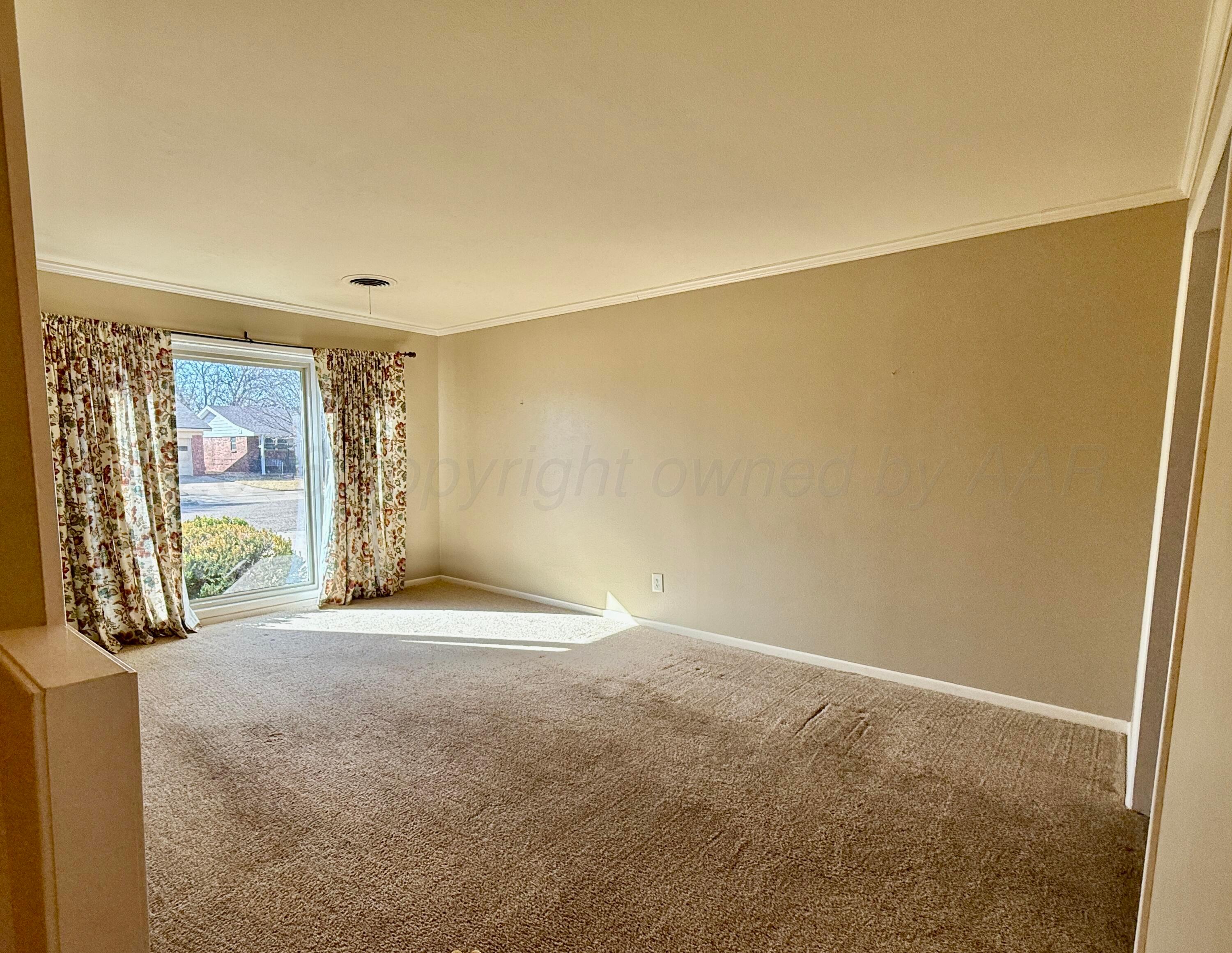 1509 Pellinore Street Borger, TX 79007 - Photo 5 of 22 a view of an empty room with wooden floor and a window