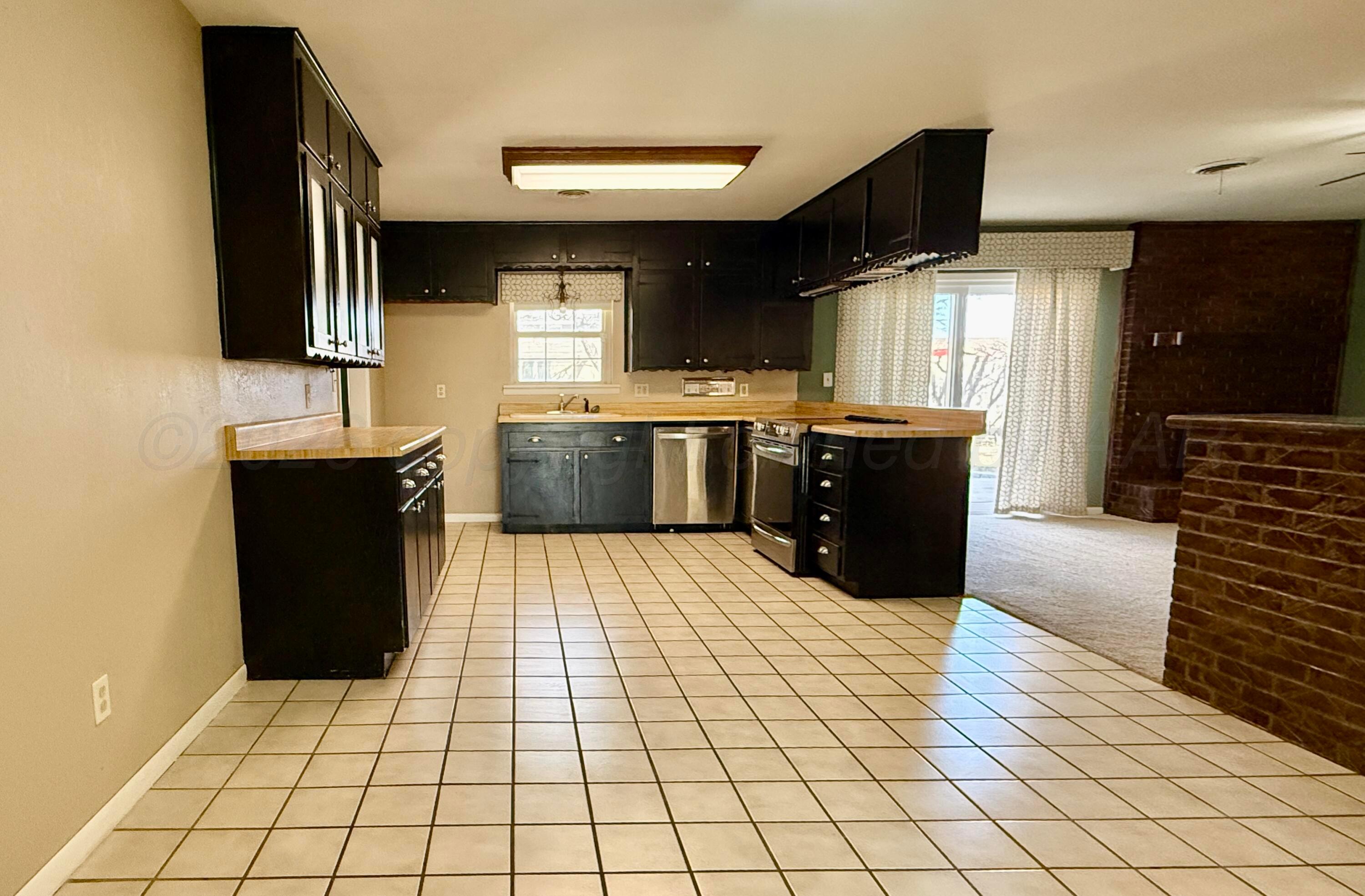 1509 Pellinore Street Borger, TX 79007 - Photo 7 of 22 a kitchen with stainless steel appliances kitchen island granite countertop a sink and cabinets