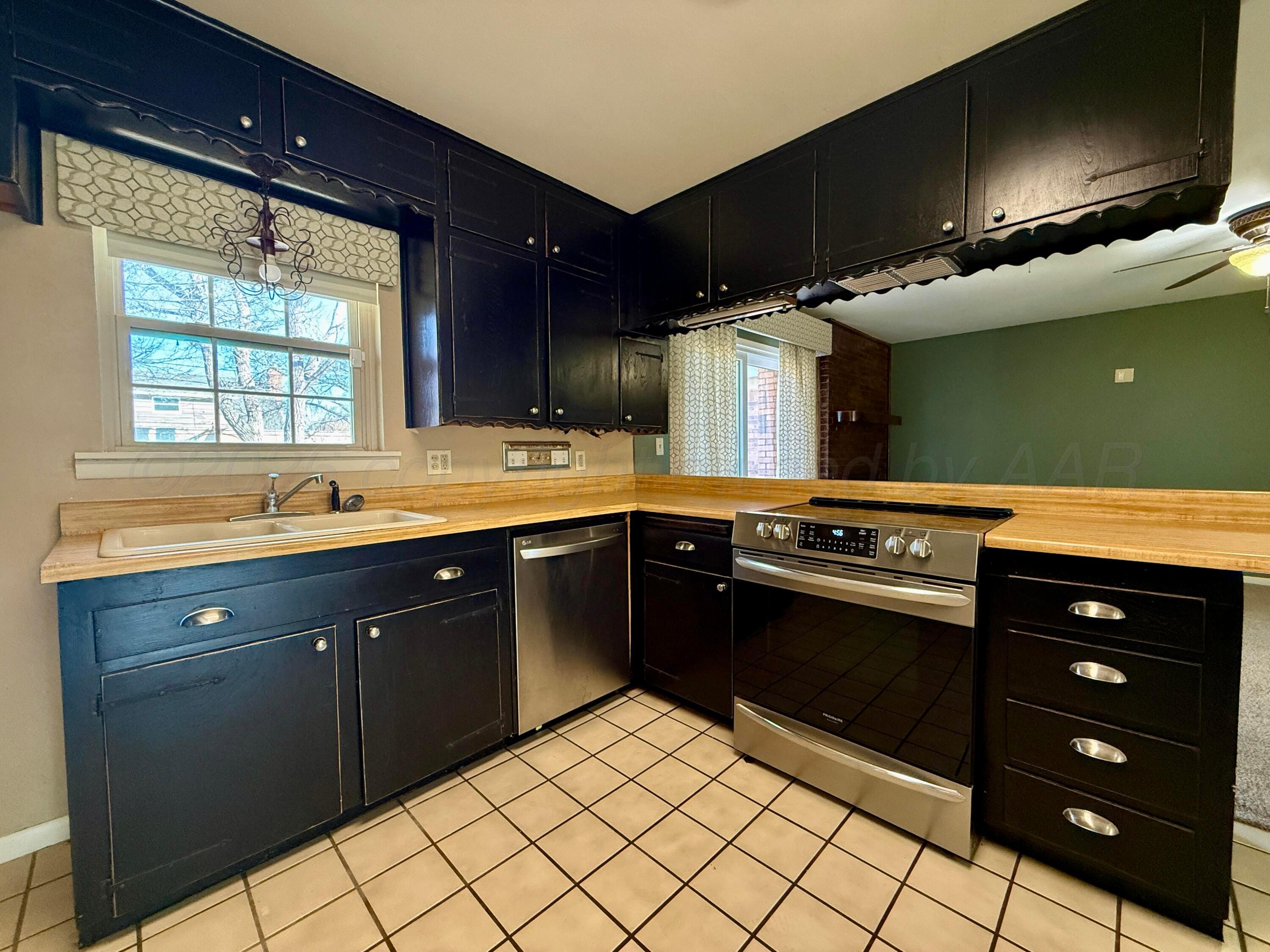 1509 Pellinore Street Borger, TX 79007 - Photo 9 of 22 a kitchen with stainless steel appliances granite countertop a sink and a stove