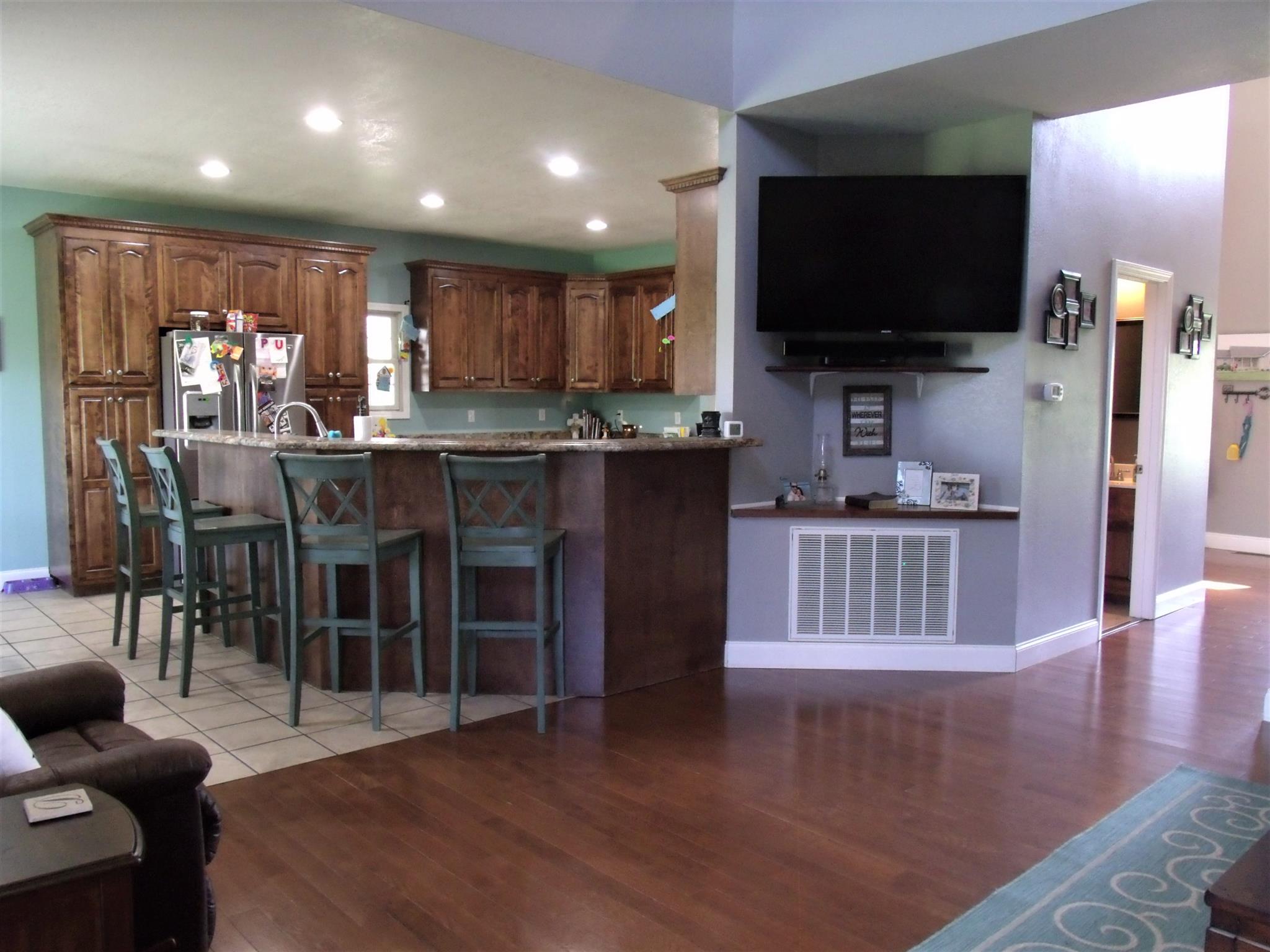 3550 Williams Cove Road Winchester, TN 37398 - Photo 6 of 26 a kitchen with stainless steel appliances kitchen island granite countertop a stove top oven a sink a dining table and chairs with wooden floor