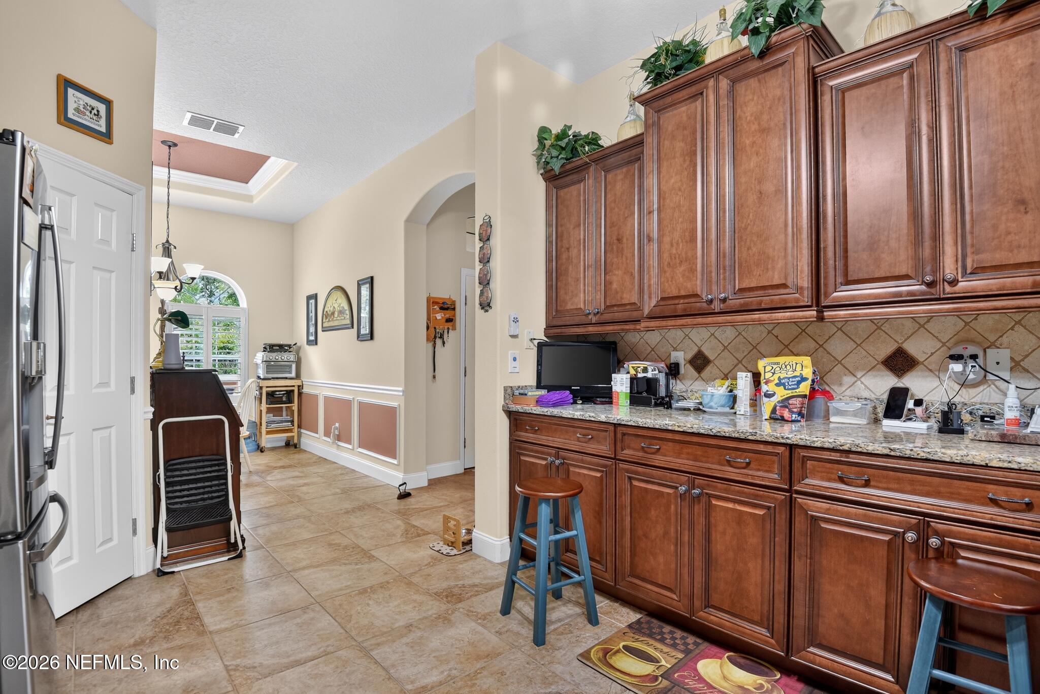 110 Vía Roma Ormond Beach, FL 32174 - Photo 16 of 43 a kitchen with granite countertop a cabinets and chairs